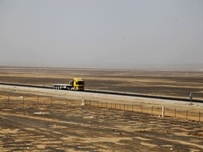 In this Nov. 27, 2017 photo, a truck drives down a bleak desert highway near the city of Azraq, Jordan where the government announced it will build a yet-to-be-named new city. The shiny new high-tech utopian city is planned to rise from Jordan's bleak desert over the next three decades, potentially rivaling the capital of Amman, a congested, increasingly unwieldy metropolis of 4 million people. Critics say it's often more efficient to address problems in existing cities and that new city projects tend to be risky endeavors.