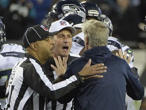 Seattle Seahawks head coach Pete Carroll is held back by officials after he ran on the field during the final moments of an NFL football game Sunday, Dec. 10, 2017, in Jacksonville, Fla. Jacksonville won 30-24. Carroll got flagged for coming onto the field.