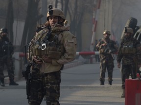 Afghan security personnel keep watch near the site of a suicide attack in Kabul on Dec. 25, 2017.