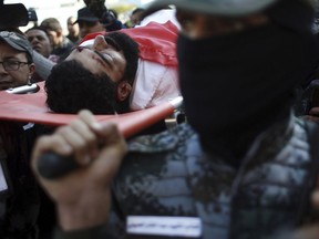 Palestinian mourners carry the body of 29-year-old activist Ibrahim Abu Thuraya who was shot and killed by Israeli troops Friday, in clashes on the Israeli border with Gaza, during his funeral in Gaza City, Saturday, Dec. 16, 2017. Abu Thuraya lost legs and an eye in Israeli bombing during the 2008 Israel and Gaza war.