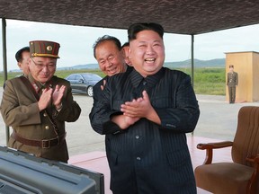 FILE - In this undated file photo distributed on Sept. 16, 2017, by the North Korean government, North Korean leader Kim Jong Un, right, celebrates what was said to be the test launch of an intermediate range Hwasong-12 missile at an undisclosed location in North Korea. North Korea says it will never give up its nuclear weapons as long as the United States and its allies continue their "blackmail and war drills" at its doorstep. Independent journalists were not given access to cover the event depicted in this image distributed by the North Korean government. The content of this image is as provided and cannot be independently verified. (Korean Central News Agency/Korea News Service via AP, File)