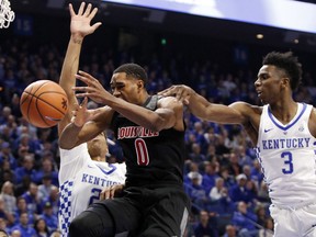 Louisville's V.J. King (0) is pressured by Kentucky's Hamidou Diallo (3) and Shai Gilgeous-Alexander during the first half of an NCAA college basketball game, Friday, Dec. 29, 2017, in Lexington, Ky.