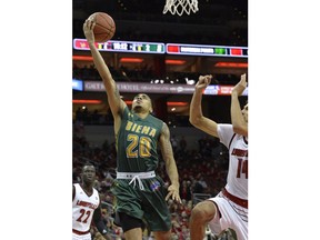 Siena guard Roman Penn (20) goes in for a layup ahead of the defense of Louisville forward Anas Mahmoud (14) during the first half of an NCAA college basketball game, Wednesday, Dec. 6, 2017, in Louisville, Ky.