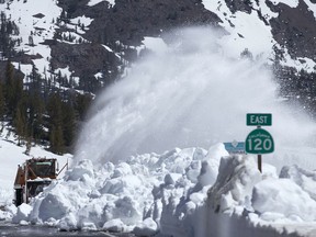 FILE - In this June 6, 2017 file photo, a Caltrans rotary blower clears snow from Highway 120 in the Sierra Nevada near Yosemite National Park, Calif. Loss of water from rocks during drought caused California's Sierra Nevada to rise nearly an inch (2.5 centimeters) in height from October 2011 to October 2015, according to a new NASA study made public Wednesday, Dec. 13, 2017. The study also found that in the following two years of increased snow and rain, the rocks in the range regained about half as much water as was lost during the drought and the return of the weight caused the height of the mountains to fall about half an inch.