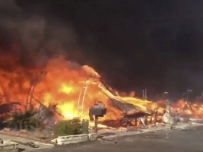 In this video grabbed image released by the San Diego Fire Department Strike Team @SDFD shows a row of homes burning in the Lilac fire in Bonsall, Calif. A brush fire driven by gusty winds that have plagued Southern California all week exploded rapidly Thursday north of San Diego, destroying dozens of trailer homes in a retirement community and killing race horses at an elite training facility. (San Diego Fire Department via AP)