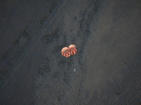 This photo released by NASA shows a replica Orion Spacecraft dropped from a U.S. Air Force C-17 transport aircraft at 35,000 feet in altitude to a southwestern Arizona desert site to test the craft's ability to cope with a partial parachute failure at the U.S. Army Proving Ground in Yuma, Ariz., Friday, Dec. 15, 2017. The test used two of Orion's three main parachutes to simulate the failure of the third and still sufficiently slowed the spacecraft for a landing. It was the fifth of eight tests to qualify Orion's parachute system for flights with astronauts beginning with Exploration Mission-2. (U.S. Army/NASA via AP)