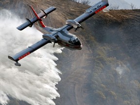 In this photo provided by the Santa Barbara County Fire Department, a Bombardier 415 Super Scooper makes a water drop on hot spots along the hillside east of Gibraltar Road in Santa Barbara, Calif., Sunday morning, Dec. 17, 2017. Wind gusts of up to 52 mph have been recorded in the area using a hand held weather device. The Office of Emergency Services announced the orders Saturday as Santa Ana winds pushed the fire close to the community. The mandatory evacuation zone is now 17 miles long and up to 5 miles wide, extending from coastal mountains northwest of Los Angeles to the ocean. Winds in the foothill area are hitting around 30 mph, with gusts up to 60 mph.