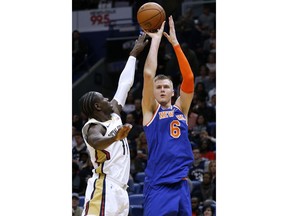 New York Knicks forward Kristaps Porzingis (6) shoots over New Orleans Pelicans guard Jrue Holiday (11) during the first half of an NBA basketball game in New Orleans, Saturday, Dec. 30, 2017.