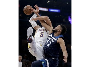 Minnesota Timberwolves center Karl-Anthony Towns, right, battles for a rebound with Los Angeles Lakers guard Josh Hart during the first half of an NBA basketball game in Los Angeles, Monday, Dec. 25, 2017.