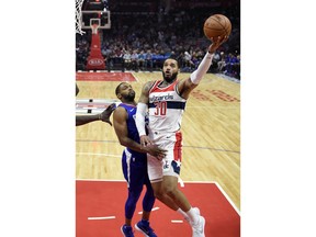 Washington Wizards forward Mike Scott, right, shoots as Los Angeles Clippers guard Sindarius Thornwell defends during the first half of an NBA basketball game, Saturday, Dec. 9, 2017, in Los Angeles.