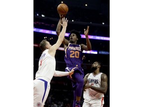 Phoenix Suns forward Josh Jackson, middle, shoots between Los Angeles Clippers forward Sam Dekker, left, and center DeAndre Jordan during the first half of an NBA basketball game in Los Angeles, Wednesday, Dec. 20, 2017.