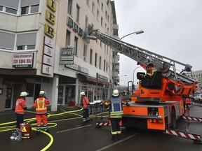 Firefighters are busy after a fire broke out in a multi-story building in Saarbruecken, western Germany, Sunday, Dec. 3, 2017. Authorities say at least four people have been killed and 23 injured in the fire.