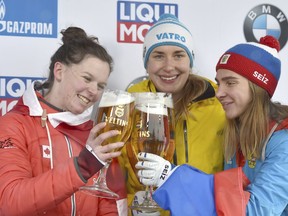 Germany's winner Jacqueline Loelling, center, celebrates with second placed Elisabeth Vathje of Canada, left, and third placed Elena Nikitina of Russia after the skeleton World Cup race in Winterberg, Germany, Friday, Dec. 8, 2017.