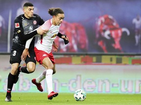 Leipzigs Yussuf Poulsen, right, and Mainz' Leon Balogun challenge for the ball during the German Bundesliga soccer match between RB Leipzig and FSV Mainz 05 at the Red Bull Arena in Leipzig, Germany, Saturday, Dec. 9, 2017.