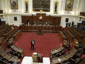 A congressman paces the empty congressional chamber while on his phone as he waits the start of a vote on whether to initiate impeachment proceeding against the country's president, in Lima, Peru, Friday, Dec. 15, 2017. Opponents demanded President Pedro Pablo Kucyznski resign over revelations of decade-old payments from Odebrecht, a Brazilian construction company, at the center of Latin America's biggest graft scandal.