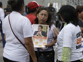 A small group of supporters of former President Alberto Fujimori talk outside the clinic where the jailed leader was hospitalized, in Lima, Peru, Tuesday, Dec. 26, 2017. Peru's President Pedro Pablo Kuczynski granted a medical pardon to the jailed former strongman who was serving a 25-year sentence for human rights abuses, corruption and the sanctioning of death squads.
