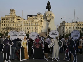 Figures of Peruvian national heroes carrying anti-Fujimori sayings stand during an anti-corruption march against both Fujimori's party and Peru's President Pedro Pablo Kuczynski in Lima, Peru, Wednesday, Dec. 20, 2017. Congressional opposition leaders from Keiko Fujimori's party initiated impeachment proceedings against Kuczynski for alleged corruption.