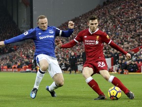 Everton's Wayne Rooney, left, and Liverpool's Andrew Robertson battle for the ball during their English Premier League soccer match at Anfield, Liverpool, England, Sunday, Dec. 10, 2017.