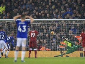 Everton's Wayne Rooney, second left, scores his side's first goal of the game from the penalty spot during their English Premier League soccer match against Liverpool at Anfield, Liverpool, England, Sunday, Dec. 10, 2017.