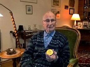 Finnish World War II veteran and Olympic athlete Torsten Liljeberg, aged 101, sits in his home in Helsinki, Finland on Friday Dec. 1, 2017, and shows a replica medal from the 2016 Rio de Janeiro Olympics that was presented to him by the International Canoeing Federation for his long canoeing career and contribution to the sport.
