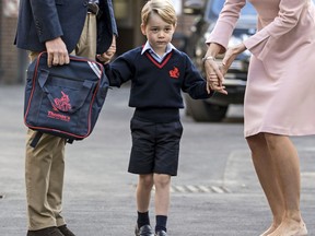 FILE - In this Thursday, Sept. 7, 2017 file photo, Britain's Prince William accompanies Prince George as he is met by Helen Haslem - the head of the lower school on arrival for his first day of school at Thomas's school in Battersea, London. A 31-year-old man has been charged in England with sharing a photo of Prince George and details about his pre-school in a social media post prosecutors allege was meant to help others plan terror attacks, it was announced on Wednesday, Dec. 6, 2017. Prosecutors allege Husnain Rashid put the information about the 4-year-old son of Prince William and the former Kate Middleton on the encrypted platform Telegram. Britain's Sun newspaper reports that Rashid allegedly posted the silhouette of an Islamic State fighter beside George.