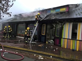 In this handout photo provided by the London Fire Brigade, firefighters work at the scene at Adventure cafe and shop near the Meerkat enclosure at London Zoo, London, Saturday, Dec. 23, 2017. London Zoo officials say a fire that broke out before the facility opened Saturday morning left one aardvark dead and four meerkats missing and presumed dead. Staff members were treated for smoke inhalation and shock after the blaze broke out near the zoo cafe in the early morning hours. (London Fire Brigade via AP)