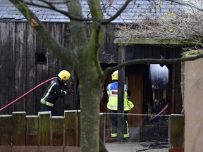 Firefighters work at the scene of a fire, at the Adventure cafe and shop near the Meerkat enclosure at London Zoo, in London, Saturday Dec. 23, 2017.  A fire at London Zoo has been brought under control but it is not clear if any animals were injured. Zoo officials initially said Saturday morning "it is not believed" animals were hurt after the blaze broke out in a zoo cafe near an animal petting area, but later reports suggested at least one animal may be missing.