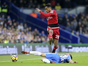 Watford's Andre Carrillo, in air, and Brighton & Hove Albion's Markus Suttner battle for the ball during the English Premier League soccer match between Brighton and Watford,  at the AMEX Stadium, in Brighton, England, Saturday, Dec. 23, 2017.
