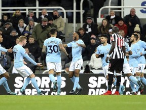 Manchester City's Raheem Sterling, center, celebrates with teammates after scoring his side's first goal of the game during their English Premier League soccer match against Newcastle United at St James' Park, Newcastle, England, Wednesday, Dec. 27, 2017.