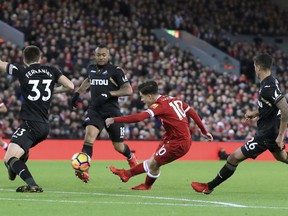 Liverpool's Philippe Coutinho scores his side's first goal of the game against Swansea City during the English Premier League soccer match at Anfield, Liverpool, England, Tuesday Dec. 26, 2017.