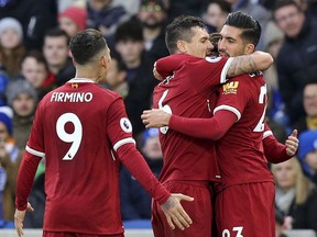 Liverpool's Emre Can, right, celebrates scoring his side's first goal with team-mates Dejan Lovren, centre, and Roberto Firmino during the English Premier League soccer match between Brighton & Hove Albion and Liverpool FC at the AMEX stadium, Brighton, England. Saturday. Dec. 2, 2017.