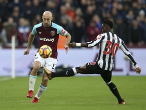 West Ham United's Pablo Zabaleta, left, and Newcastle United's Christian Atsu battle for the ball during the English Premier League soccer match at the London Stadium, London, Saturday, Dec. 23, 2017.