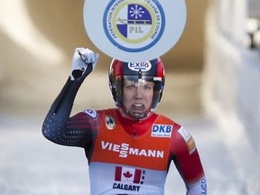 Canada's Alex Gough, slaps the paddle after crossing the finish line during the team relay event at the World Cup luge competition in Calgary, Saturday, Dec. 9, 2017.