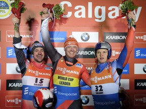 Calgary's Samuel Edney, left, stands on the podium with gold medal winner Felix Loch, centre, of Germany and bronze medallist Roman Repilov of Russia after winning silver at the World Cup luge event in Calgary on Friday. It was the 33-year-old's final race in front of his hometown fans.