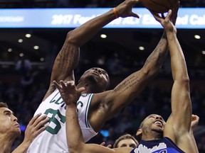 Boston Celtics guard Marcus Smart, left, grabs a rebound over Dallas Mavericks guard Devin Harris (34) during the second quarter of an NBA basketball game in Boston, Wednesday, Dec. 6, 2017.