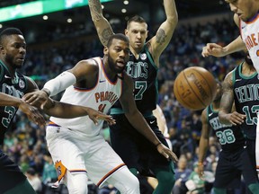 Phoenix Suns' Greg Monroe (14) and Devin Booker (1) battle for a loose ball with Boston Celtics' Semi Ojeleye, left, and Daniel Theis, center right, during the second quarter of an NBA basketball game in Boston, Saturday, Dec. 27, 2017.