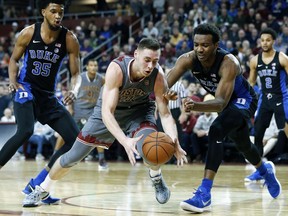 Boston College's Nik Popovic, center left, and Duke's Wendell Carter Jr, center right, chase a loose ball during the first half of an NCAA college basketball game in Boston, Saturday, Dec. 9, 2017.