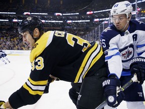 Boston Bruins' Zdeno Chara (33), of Slovakia, and Winnipeg Jets' Mark Scheifele (55) battle along the boards during the first period of an NHL hockey game in Boston, Thursday, Dec. 21, 2017.