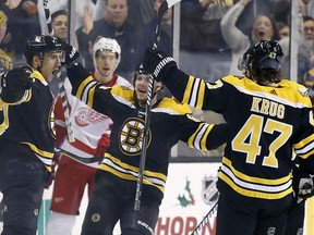 Boston Bruins' Patrice Bergeron, left, celebrates his goal with teammates including Torey Krug (47) during the third period of an NHL hockey game against the Detroit Red Wings in Boston, Saturday, Dec. 23, 2017. The Bruins won 3-1.