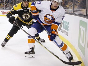 Boston Bruins' Zdeno Chara (33), of Slovakia, battles New York Islanders' Anders Lee (27) for the puck during the first period of an NHL hockey game in Boston, Saturday, Dec. 9, 2017.