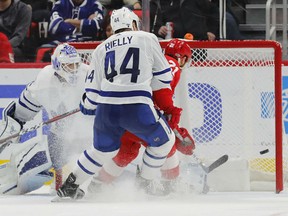 Tomas Tatar of the Red Wings scores on Toronto Maple Leafs goalie Curtis McElhinney as Morgan Rielly looks on during the third period of their game Friday night in Detroit.