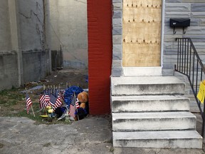 In this Monday, Nov. 27, 2017 photo, a makeshift memorial sits in an alley where Baltimore Police Detective Sean Suiter was shot while investigating a 2016 triple homicide in Baltimore. The murder of Suiter, who was shot in the head with his own gun two weeks ago, has transformed into a feeding frenzy of speculation in a city filled with armchair sleuths and deeply suspicious views of law enforcers. Suiter's Baltimore-area funeral procession was set to close down major roads Wednesday. (AP Photo/Patrick Semansky)