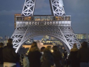 The words "Thank you Johnny" is displayed on the Eiffel Tower referring to late French rock star Johnny Hallyday in Paris, France, Friday, Dec. 8, 2017. French President Emmanuel Macron and hundreds of thousands of fans are expected to pay tribute to the late French rock star Johnny Hallyday on Saturday as his funeral procession weaves through Paris.