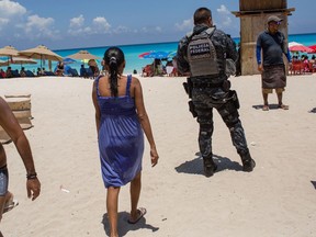 A federal officer patrols a beach in Cancun, Mexico, on July 11, 2017. (MUST CREDIT: Brett Gundlock/Bloomberg)