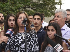 FILE - In this June 16, 2017 file photo, Lindsey Hamama, 11, right, cries as her mother Nahrain speaks to the crowd in Detroit, about her father Usama "Sam" Hamama, who was detained during Immigration and Customs Enforcement raids of primarily Chaldean immigrants, in which 114 Iraqi nationals in Metro Detroit were detained and are facing deportation. A federal judge in Detroit is mulling whether to release her father, Hamama, who was apprehended by immigration officials as part of a roundup in June, and hundreds of others whose deportations to Iraq were suspended but remain in custody. U.S. District Judge Mark Goldsmith, who will hear arguments on Wednesday, Dec. 20, 2017, blocked the deportation of 1,400 people in July to allow time to challenge their removal in immigration court.