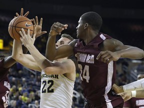 Michigan guard Duncan Robinson (22) pulls down a rebound next to Alabama A&M forward Evan Wiley (24) during the first half of an NCAA college basketball game Thursday, Dec. 21, 2017, in Ann Arbor, Mich.