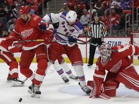 Detroit Red Wings defenseman Jonathan Ericsson (52) and New York Rangers right wing Rick Nash (61) try controlling the puck in front of Red Wings goalie Jimmy Howard during the first period of an NHL hockey game, Friday, Dec. 29, 2017, in Detroit.