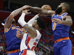 New York Knicks forward Michael Beasley (8) and center Kyle O'Quinn (9) block a shot by Detroit Pistons forward Eric Moreland (24) during the first half of an NBA basketball game, Friday, Dec. 22, 2017, in Detroit.