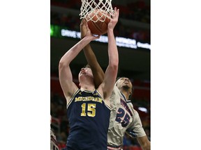 Michigan center Jon Teske (15) is fouled by Detroit forward Gerald Blackshear Jr. (25) while going to the basket during the first half of an NCAA college basketball game Saturday, Dec. 16, 2017, in Detroit.