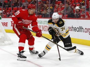 Detroit Red Wings defenseman Danny DeKeyser (65) and Boston Bruins left wing Jake DeBrusk (74) battle for the puck in the first period of an NHL hockey game Wednesday, Dec. 13, 2017, in Detroit.